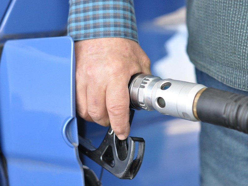 Mano de hombre echando gasolina.